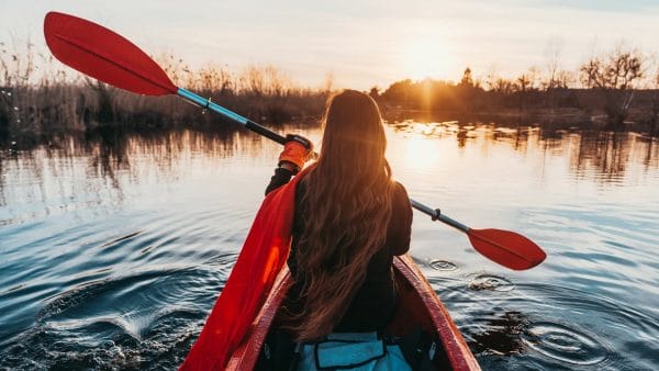 picture of woman in a kayak at sunset
